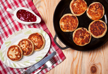 Beautiful golden cheese pancakes fried in a pan. Syrniki.