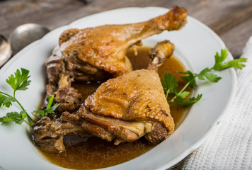 Roasted duck legs on white plate