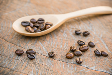 close up of Coffee beans with wooden spoon on grunge wooden background