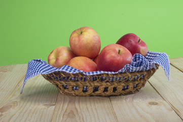 apples in a basket on a wooden background