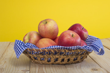apples in a basket on a wooden background