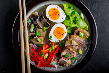Noodles with egg and duck meat in bowl