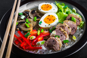 Noodles with egg and duck meat in bowl