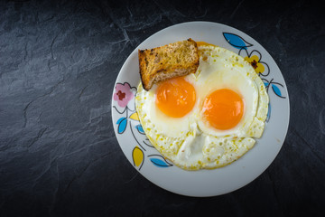 Huevo frito con dos yemas y pan tostado