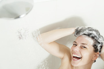 Shower woman. Happy smiling woman washing shoulder showering in 