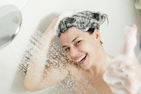 Shower woman. Happy smiling woman washing shoulder showering in 