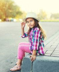 Fashion little girl child wearing a checkered pink shirt and hat