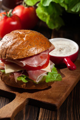 Delicious sandwich with prosciutto ham, cheese and vegetables