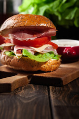 Delicious sandwich with prosciutto ham, cheese and vegetables