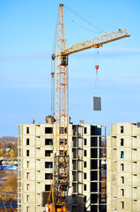 Industrial work at building site - lifting of  concrete slab by tower crane.  View from height.