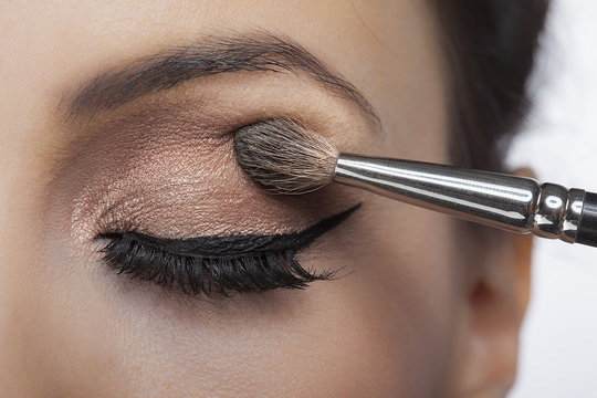 Makeup close-up. Eyebrow makeup, long eyelashes, brush.