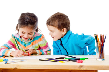 Two little kids draw with crayons