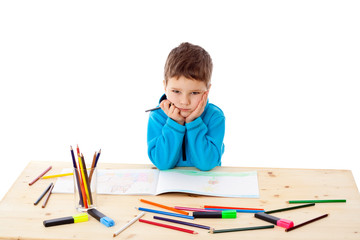 Sad little boy draw with crayons