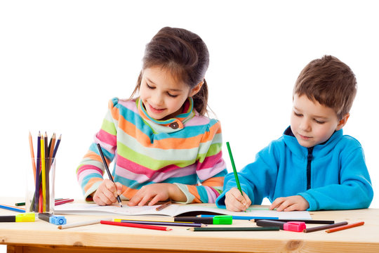 Two little kids draw with crayons together