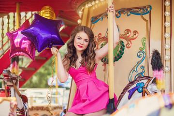 Fototapeta na wymiar Beautiful young girl on a merry go round