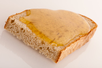 Sweet sticky golden honey on a slice of fresh bread.