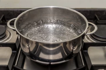  Metal cooking pan with boiling water on a stove © Roen