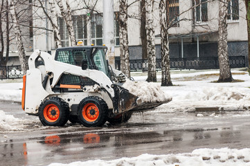 loader removes snow on city streets