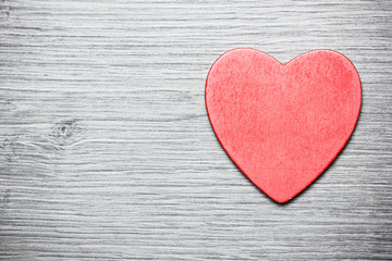 Fototapeta na wymiar Single red wooden heart on wood.