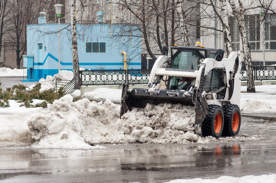 loader removes snow on city streets