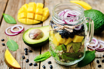 homemade healthy salads with black beans, vegetables, fruits, an