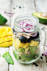 homemade healthy salads with black beans, vegetables, fruits, an