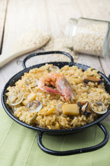 Vegetable paella with seafood on a wooden background