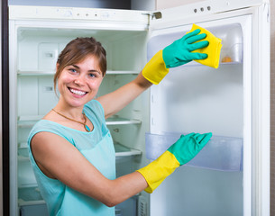 woman cleaning empty refrigerator