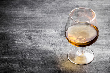 Cognac glass on black surface.