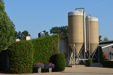 Fodder silo's on a farm behind a green hedge © lembrechtsjonas