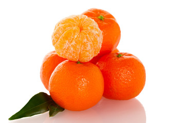 Fresh unpeeled orange mandarin citrus with green leafs and half