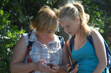 Hiking woman and girl reading a gps