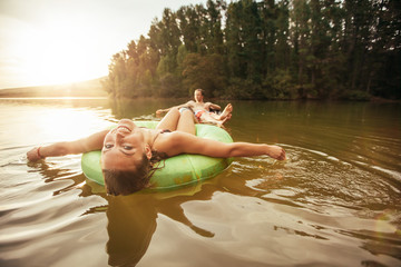 Young woman in lake on inflatable rings.