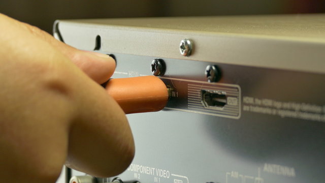 A close-up shot of a workman plugging-in an HDMI cable to the back of :Ultra HD 4K High quality footage size (3840x2160)