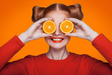 Young beautiful fashion model with orange. studio shot.