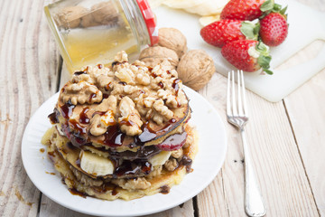 Pancakes with banana , walnut & chocolate on wood background