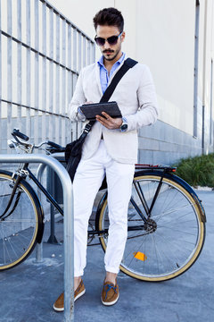 Young businessman using a digital tablet outdoors.