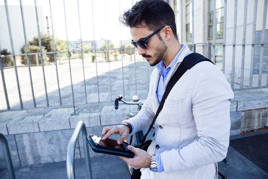 Young businessman using a digital tablet outdoors.