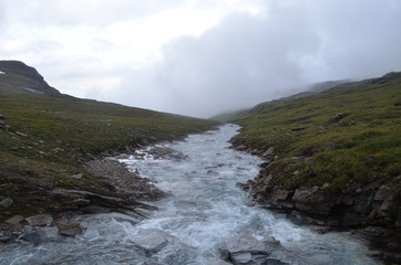 Rocky river flowing through tundra valley, subarctic mountains, Swedish Lapland