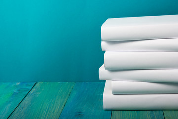 Stack of colorful books, grungy blue background, free copy space