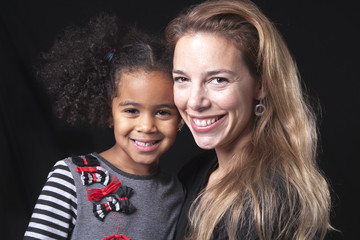 family posing on a black background studio