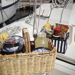 Abwaschbare Fototapete Picknick Lebensmittel mit Geschirr im Picknickkorb auf Segelboot