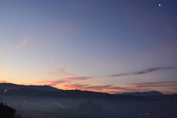 sunset over the city in fog