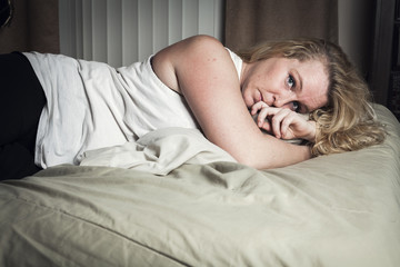 A woman feel sick lying down on bed