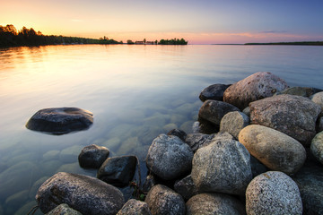 Grote rotsblokken op de oever van het meer bij zonsondergang. Minnesota, VS