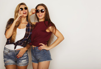 Two young girl friends standing together and having fun. 