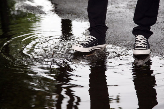  Man Stops With His Foot In A Puddle