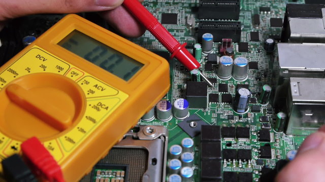 Multimeter testing electronic board charges.