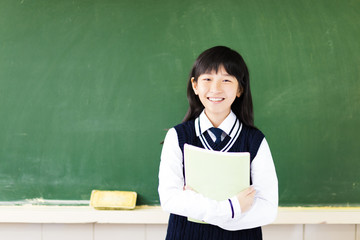 happy student girl with book in classroom