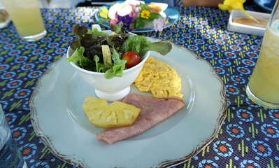 Fresh salad serving with scrambled eggs and hams